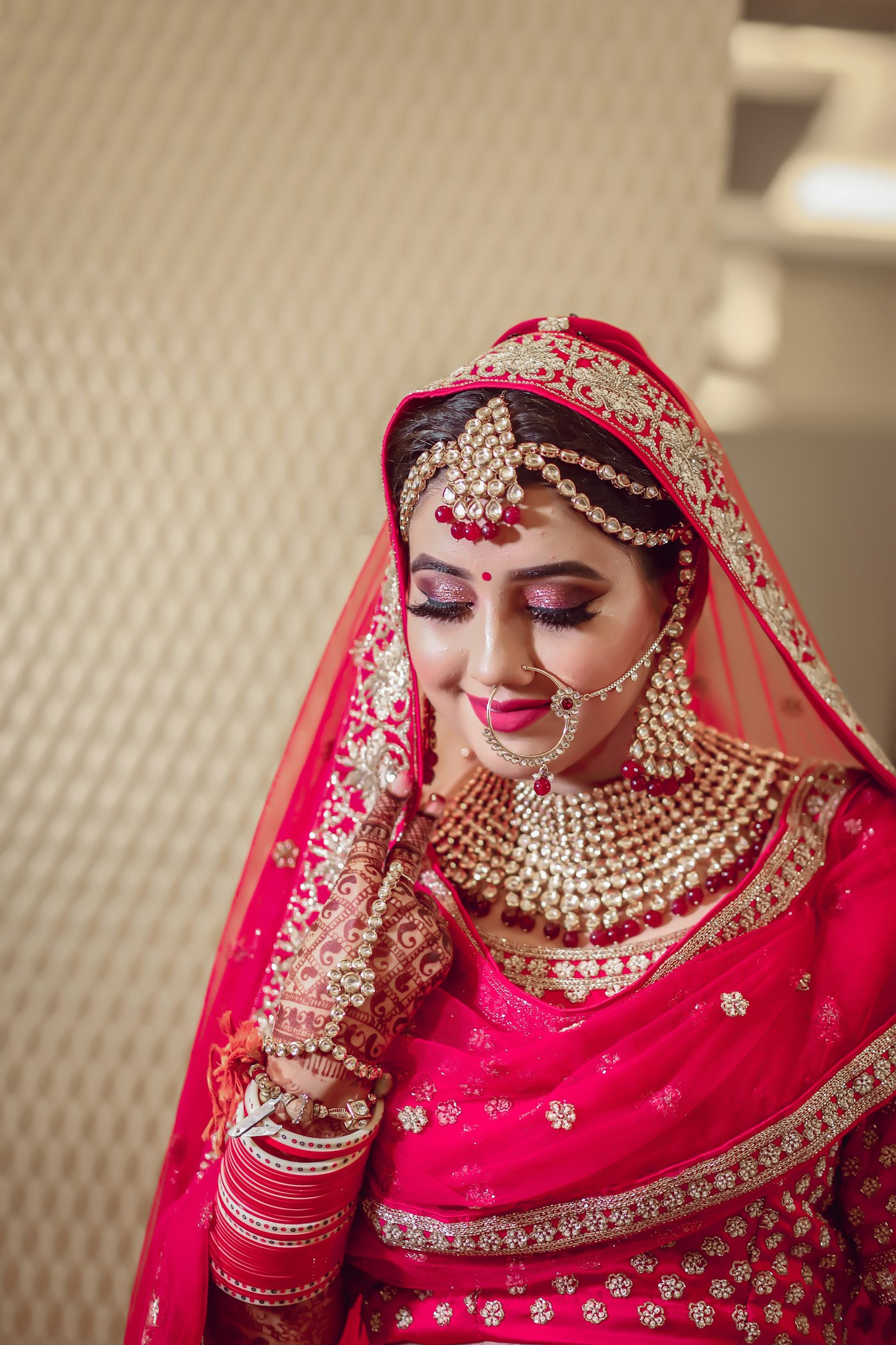 Bride in a red dupatta and gold jewellery
