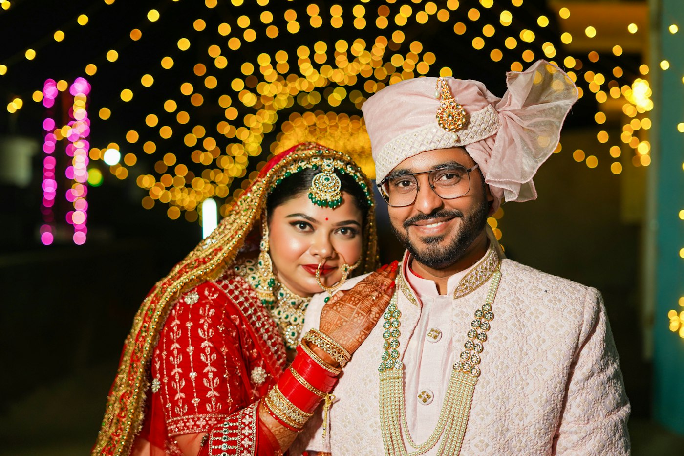 Bride and groom smiling together under warm lights